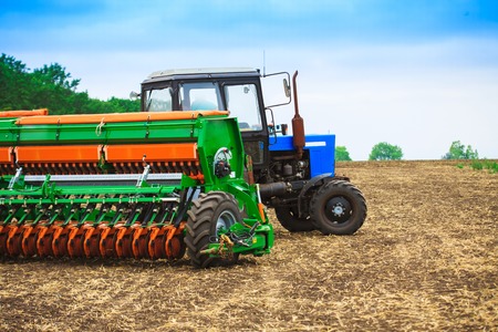 Tractor with a harrow to work the land fieldの写真素材