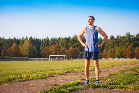 Young athletic man standing at the old stadium.の写真素材