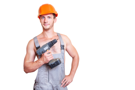 A man in overalls and helmet with a screwdriver, isolated on white background.の写真素材
