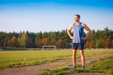 Young athletic man standing at the old stadium.の写真素材