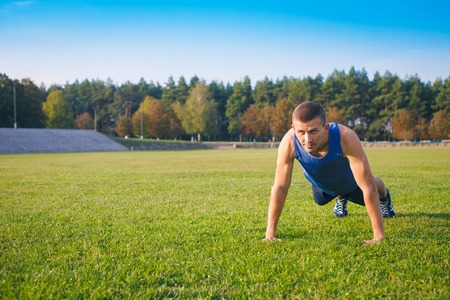 Fitness man doing push-ups on the grass. Sports and active lifestyle.の写真素材
