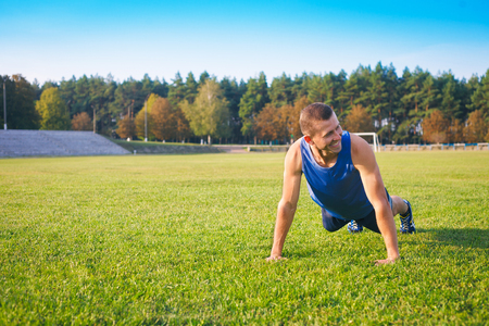 Fitness man doing push-ups on the grass. Sports and active lifestyle.の写真素材