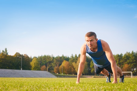 Fitness man doing push-ups on the grass. Sports and active lifestyle.の写真素材