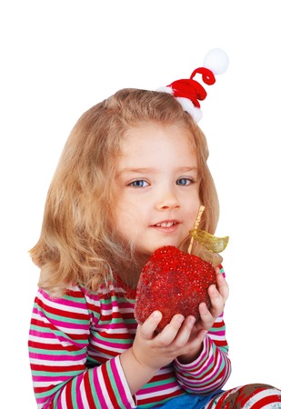 Little girl holding Christmas toys in the form of an apple, isolated on white.の写真素材