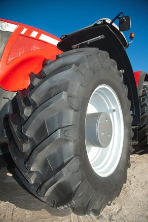 Red tractor against the clear blue sky close-upの写真素材