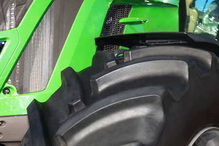 Tire on green tractor close up in the foregroundの写真素材
