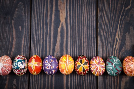 Easter eggs in a row on a dark wooden background.の写真素材