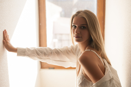 Beautiful seductive woman in underwear and a white shirt near the window.の写真素材