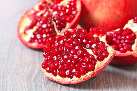 Close up sliced and whole pomegranate on a tableの写真素材