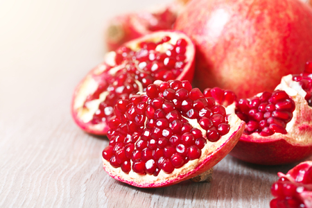 Close up sliced and whole pomegranate on a tableの写真素材