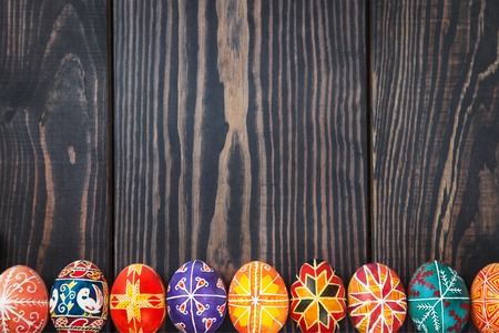 Easter eggs in a row on a dark wooden background.の写真素材
