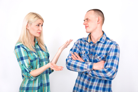Young man and woman are arguing in the studio on a white background.の写真素材