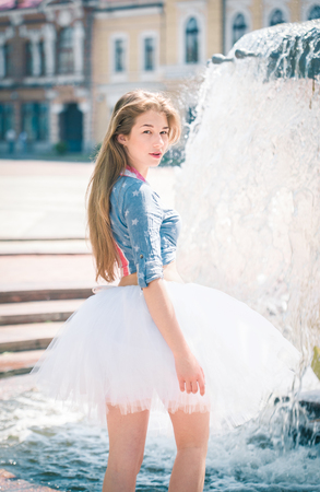 Cute young woman in fluffy skirt near the fountainの写真素材