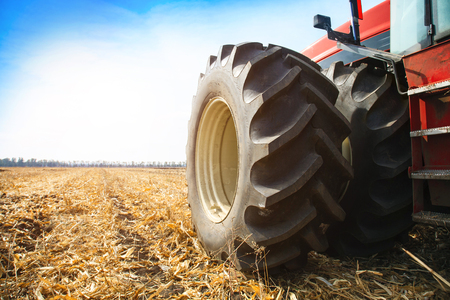 Modern red tractor in the field close-up on a bright sunny dayの写真素材