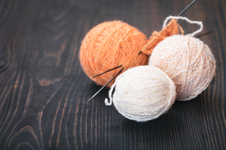 Skeins of wool thread for knitting on a wooden background.の写真素材
