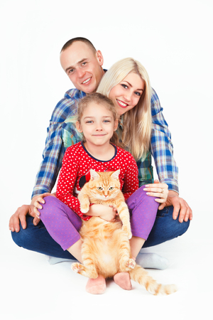 Happy family and a cat sitting in the studio on a white background.の写真素材