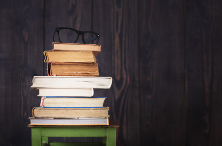 Pile of books and glasses from the top, a studio shot in retro style.の写真素材