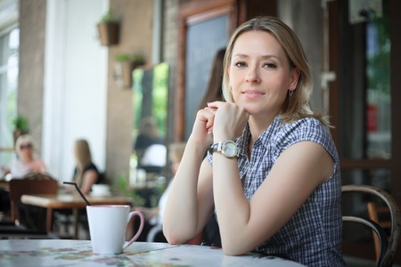 Woman drinking coffee in the morning at restaurant, soft focus on eyes.の写真素材