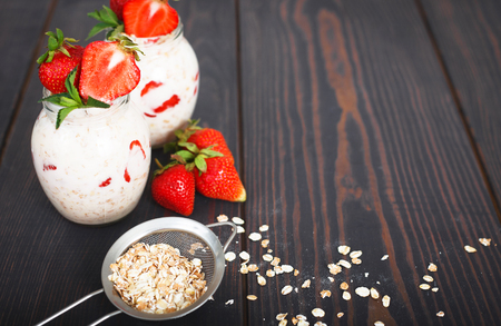 Healthy breakfast: overnight oats with fresh strawberries in a glass jar.の写真素材