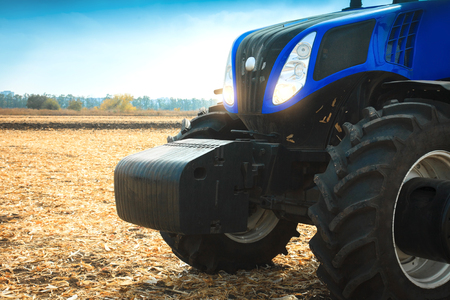 Modern tractor working in a field on a sunny day. Agricultural machinery during planting.の写真素材