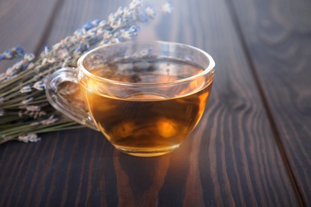 Cup of lavender tea and lavender flowers on a wooden table.の写真素材