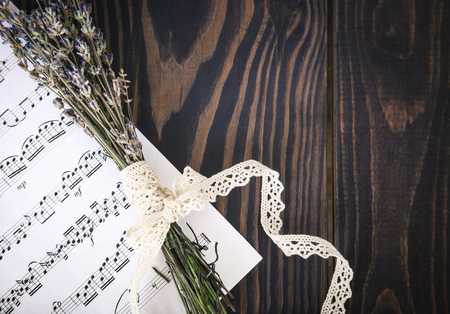 Lavender and paper music notes on old wooden background in vintage style, top view.の写真素材
