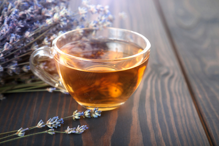 Cup of lavender tea and lavender flowers on a wooden table.の写真素材