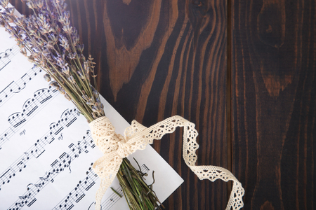 Lavender and paper music notes on old wooden background in vintage style, top view.の写真素材