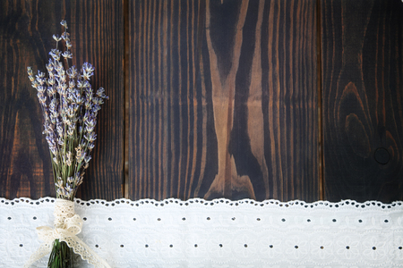 A bunch of lavender and lace on a wooden table. Background in vintage styleの写真素材