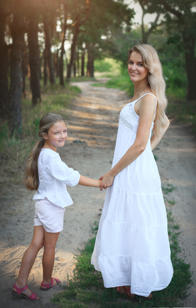 Portrait of mother and daughter while walking in nature in summer.の写真素材