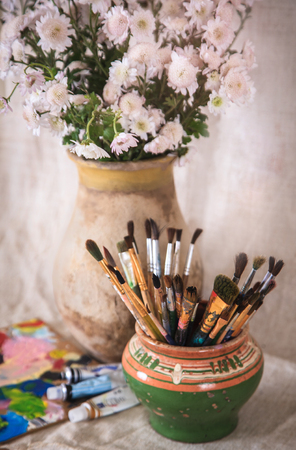 Still life with flowers and brushes in an old pot, retro styleの写真素材