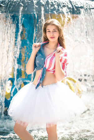 Cute young woman in fluffy skirt near the fountainの写真素材