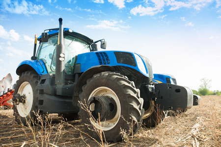 Two blue tractors in the empty field. Agricultural machineryの写真素材