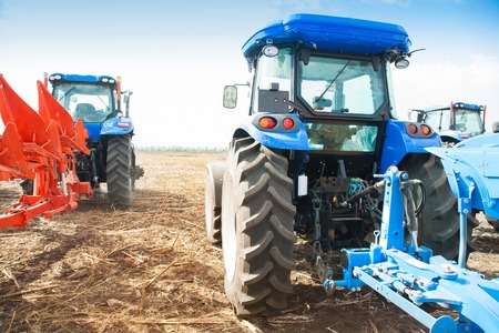Two blue tractors in the empty field. Agricultural machineryの写真素材