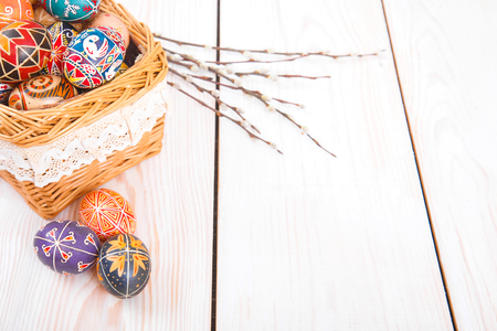 Easter eggs in a basket on a white plank background. Symbol of Christian holidays.の写真素材