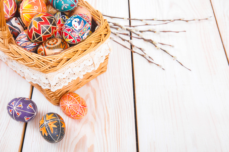 Easter eggs in a basket on a white plank background. Symbol of Christian holidays.の写真素材