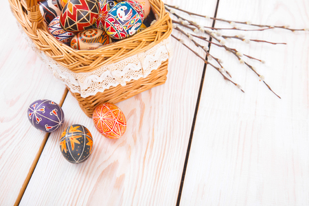 Easter eggs in a basket on a white plank background. Symbol of Christian holidays.の写真素材