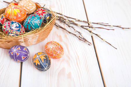 Easter eggs in a basket on a white plank background. Symbol of Christian holidays.の写真素材