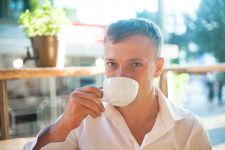 Young man enjoy on coffee break, outdoors portraitの写真素材