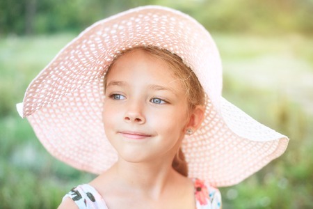 Summer portrait of a beautiful girl in a pink hat. The concept of childhood and vacations.の写真素材