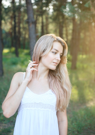 Portrait of a beautiful young woman with long hair on nature in summer.の写真素材
