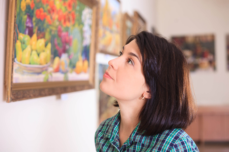 Young woman looking at painting in art gallery.の写真素材