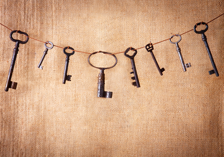 An ancient metal keys on the background of sacking. Background in vintage style.の写真素材