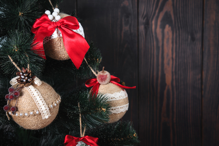 Christmas or New Year rustic wooden background with toy decorations and fur tree branch, copy space.の写真素材