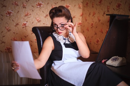 Beautiful woman with glasses sitting and reading the document.の写真素材
