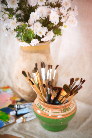 Still life with flowers and brushes in an old pot, retro styleの写真素材