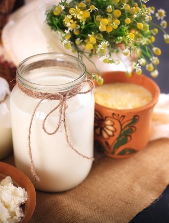A can of milk and other dairy products on the table. Still life in rural style. Farmer's cow dairy products.の写真素材