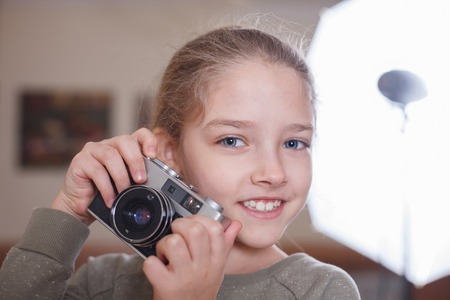 Little cute girl with a vintage camera. Studio shot.の写真素材