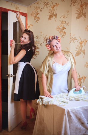 Two women do homework: ironing and cleaning. Retro style, vintageの写真素材