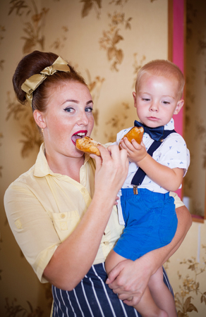 Mother and son in the kitchen with pastries. Studio shot, home interior.の写真素材